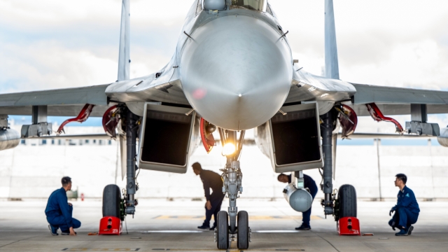 Maintenance men inspect J-16 fighter jet