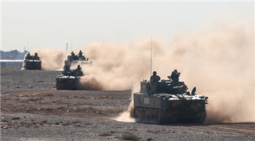 Armored vehicles rumble through desert