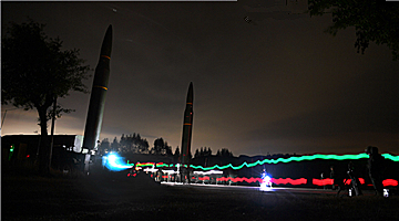 Rocket force soldiers erect ballistic missile system at night