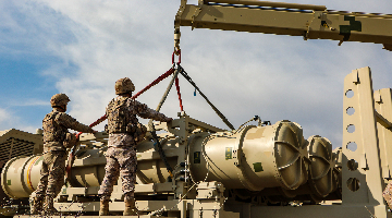 Soldiers hoist and load air-defense missiles