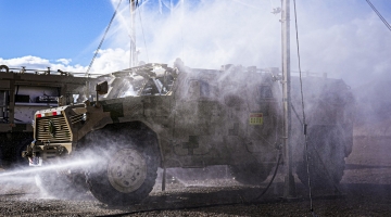 Soldiers decontaminate military vehicle