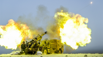 Vehicle-mounted howitzers spit fire down range