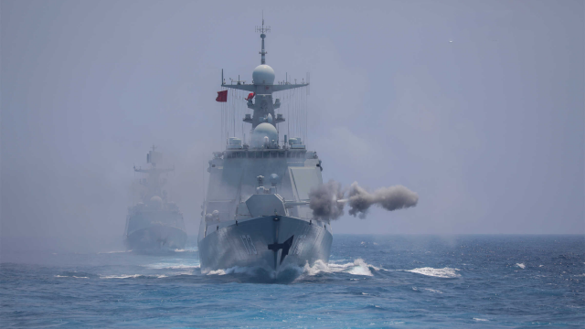 Naval vessels fire at targets during coordination training exercise