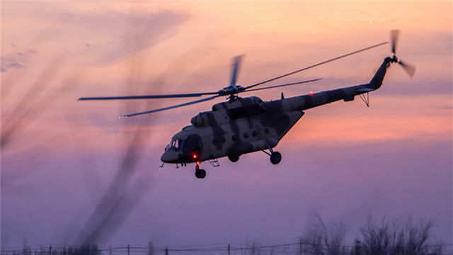 Helicopters lift off at twilight