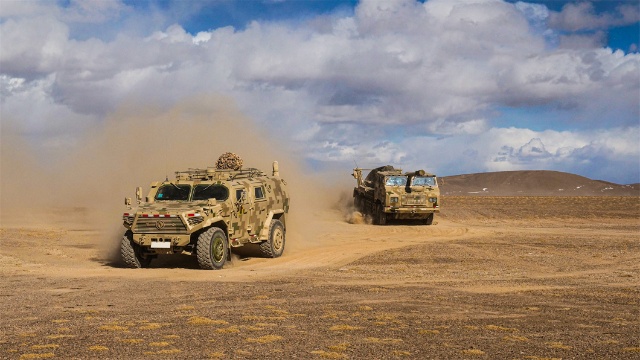 Military vehicles march on field