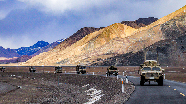 Military trucks maneuver to designated field