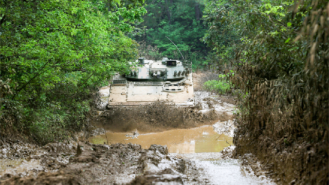 Main battle tank wades through muddy area