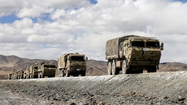 Military vehicles engage in long-distance maneuver exercise