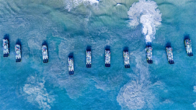 Amphibious assault vehicles sail in formation