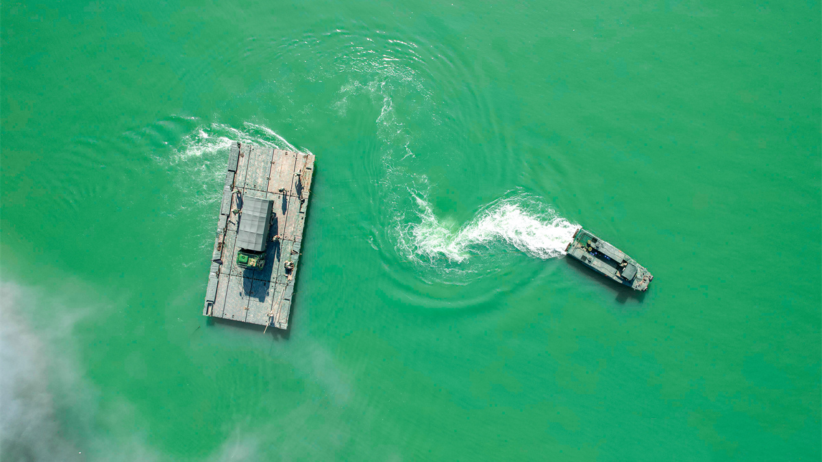 Pontoon troops ferry military vehicles across river