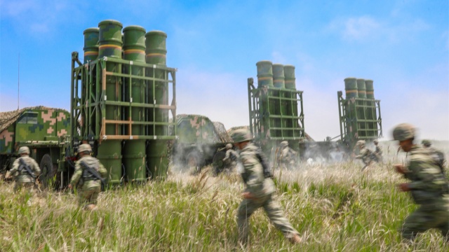 Soldiers rush toward missile launching vehicles