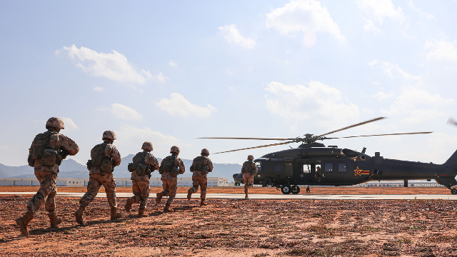Soldiers rush to board helicopter during air-ground exercise