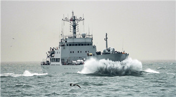 Naval vessels cleave through waves