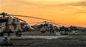 Helicopters lift off at twilight