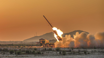 Long-range multiple rocket launcher systems fire at mock targets