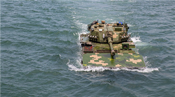 Amphibious armored vehicles maneuver toward beach-head