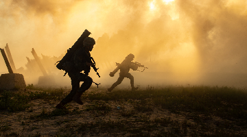 Infantrymen charge toward mock enemy on beach