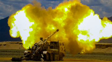 Self-propelled howitzers fire during live-fire exercise