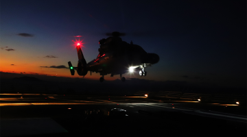 Ship-borne helicopter lifts off from helideck