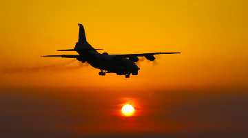 Reconnaissance aircraft flies past setting sun