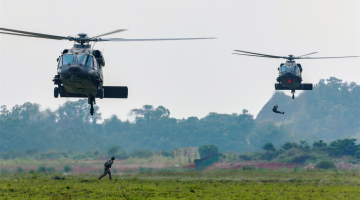 Army troops board helicopters for coordination training