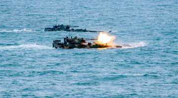 Amphibious assault vehicles spit fires at sea