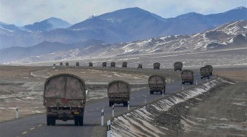 Military trucks maneuver on plateau