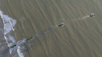 Amphibious armored vehicles sail in formation