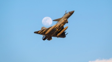 Fighter jet flies past moon