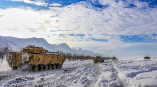 Armored vehicles march on snow field