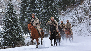 Border defense troops patrol snowfield on horseback