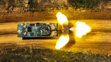 Armored vehicles fire at targets