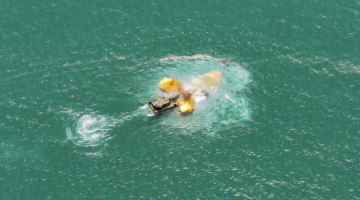 Amphibious assault vehicles open fire at sea