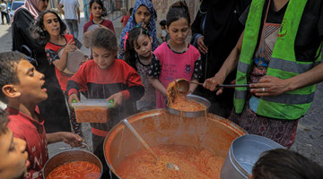 Palestinian children receive food relief in southern Gaza Strip city of Rafah