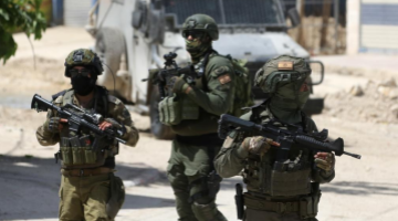 Israeli soldiers walk on street during Israeli military operation in Tulkarm refugee camp