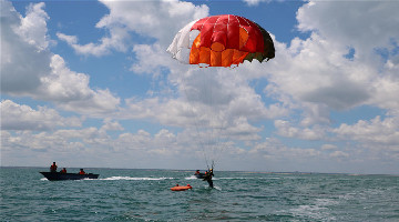 Female fighter pilots conduct water survival-parachute training