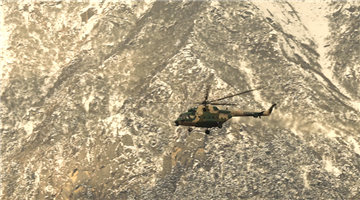Transport helicopters fly in formation over mountains