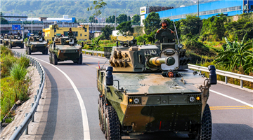 Armored assault vehicles drive on highway