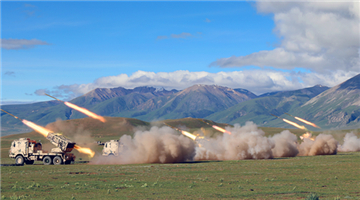 Artillerymen operate howitzers under commands