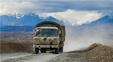 Military trucks drive through slope obstacles