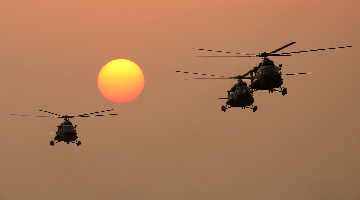 Attack helicopters' silhouette seen at sunset