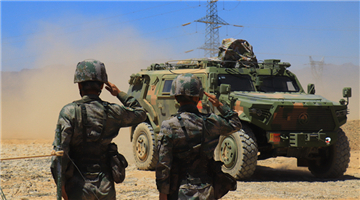 Vehicle-mounted howitzers participate in desert maneuver