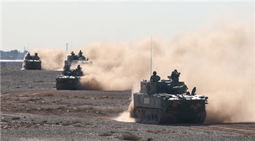 Armored vehicles rumble through desert