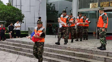 Soldiers transfer kids in torrential rain-hit Zhengzhou