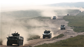 Armored vehicles maneuver to training base