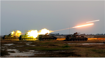 Self-propelled howitzer systems fire at targets