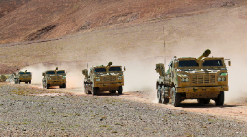Vehicle-mounted howitzers rumble through mountainous area