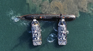 Boats tow submarine off port